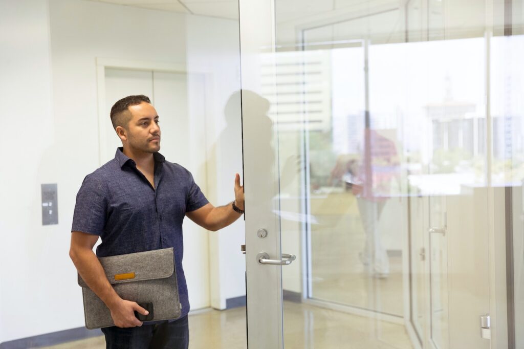 man walking into office door